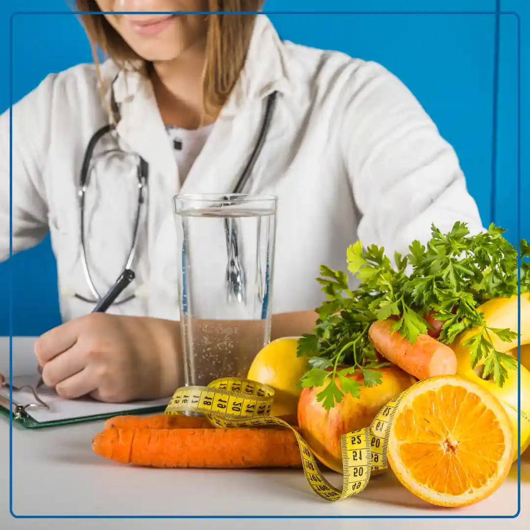 Foto di una nutrizionista che scrive una dieta ad un paziente; in primo piano un cesto di frutta e verdura. Immagine di accompagnamento all'articolo "Open day Ambulatorio di Nutrizione ed Alimentazione".