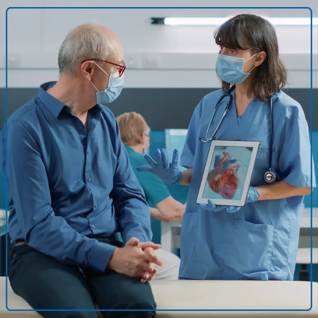 Immagine di un paziente a cui una dottoressa fa vedere su un tablet l'immagine di un cuore. Foto di accompagnamento all'articolo dedicato a "Covid-19 e patologie cardiocircolatorie".
